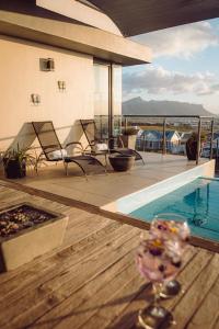 a house with a swimming pool with chairs and a table at 7 on Solara in Somerset West