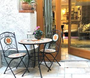 a table with two chairs and a table with a plant at Charming Apartment in Menaggio Old Town in Menaggio