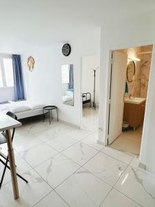 Apartment near subway and supermarket في باريس: غرفة بيضاء مع أرضية بيضاء من البلاط وطاولة