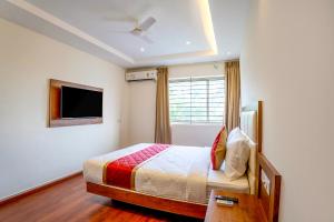 um quarto com uma cama e uma televisão em FabHotel Phoenix Horamavu em Bangalore