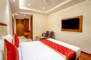 um quarto de hotel com uma cama e uma televisão de ecrã plano em FabHotel Phoenix Horamavu em Bangalore