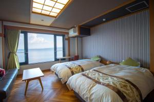 a bedroom with two beds and a large window at La se ri Resort and Stay in Himi