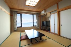 een woonkamer met een tafel en een groot raam bij La se ri Resort and Stay in Himi