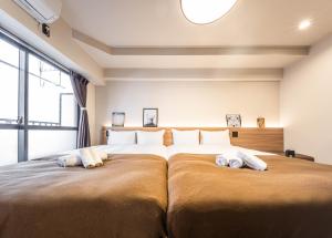 大阪的住宿－輕宿心齋橋4號店，一间卧室配有一张大床和两个枕头