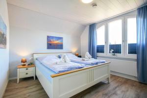 a bedroom with a large bed with a window at Ferienhaus Daheim in Borkum