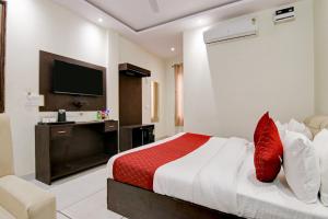 a hotel room with a bed and a television at Hotel De Hocks Deluxe - New Delhi in New Delhi