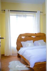 a bedroom with a bed with a large window at Mupa's Luxury Condo II in Nyahururu