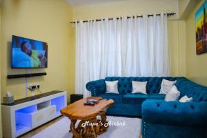 a living room with a blue couch and a table at Mupa's Luxury Condo II in Nyahururu