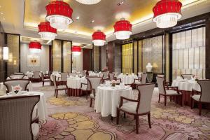 a dining room with tables and chairs and chandeliers at Wanda Realm Ningde in Ningde