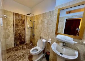 a bathroom with a toilet and a sink and a mirror at Luxury Hotel - 50/3 Trường Sơn, Q. Tân Bình - by Bayhostel in Ho Chi Minh City