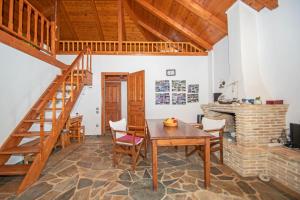 a dining room with a wooden table and a staircase at Villa Dora in Tragaki