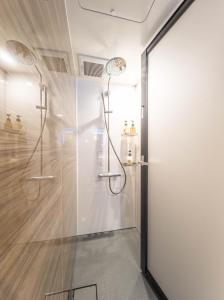 大阪的住宿－輕宿心齋橋4號店，带淋浴的浴室和玻璃门