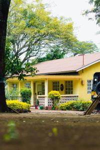une maison jaune avec un toit rouge dans l'établissement Mkoani Homestay, à Moshi