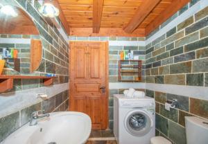 a bathroom with a sink and a washing machine at Villa Dora in Tragaki
