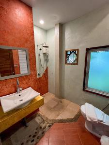 La salle de bains est pourvue d'un lavabo et de toilettes. dans l'établissement ี เรือนปณาลี รีสอร์ท, à Ban Khlong Sai Yok