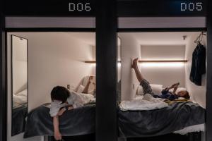 a group of people laying on beds in a room at The Millennials Kyoto in Kyoto