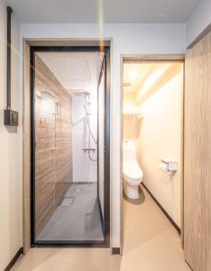 大阪的住宿－輕宿心齋橋4號店，带卫生间的浴室内的玻璃淋浴间
