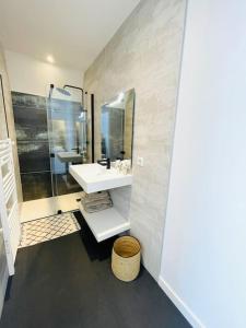 Un baño blanco con lavabo y ducha. en Villa Mary-Alex La Baule, en La Baule