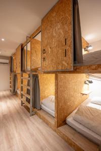 Light Hostel Hualien في مدينة هوالين: غرفة مع مجموعة من الأسرّة ذات الطابقين