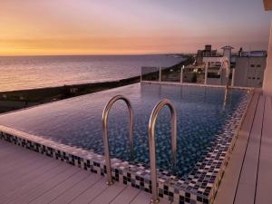 uma piscina no topo de um prédio com vista para o oceano em 愛琴海岸精品民宿 em Fang-liao