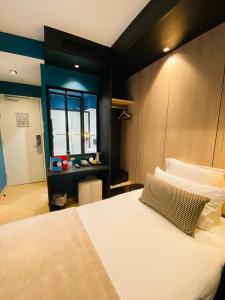 a bedroom with a large white bed with a window at Grand Hôtel Clichy Paris - Boutique Hôtel in Clichy
