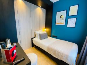 a small bedroom with a bed and a table at Grand Hôtel Clichy Paris - Boutique Hôtel in Clichy