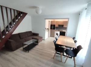 a living room with a couch and a table at Duplex Cosy in Gonesse