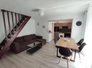 un soggiorno con un divano e un tavolo di Duplex Cosy a Gonesse