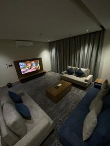 sala de estar con 2 sofás y TV de pantalla plana en شقة فندقية Elite Corner en Riad