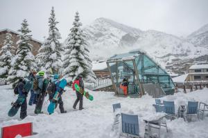 a group of people standing in the snow with snowboards at Hotel Bonavida in Canillo