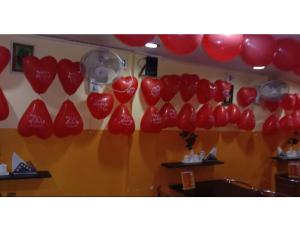 a bunch of red heart balloons hanging on a wall at Central Guest House, Tripura in Agartala