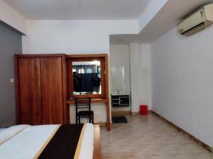 1 dormitorio con cama, escritorio y espejo en i-Jas Rock N View, en Meenangadi