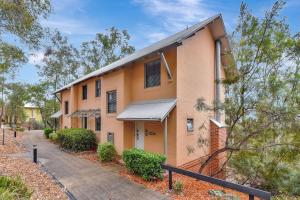 um edifício laranja com um passeio em frente em Villa 2br Nebbiolo Villa located within Cypress Lakes Resort em Pokolbin