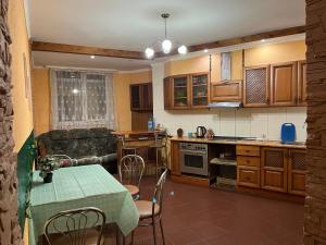 ArArAt-OSOKORKI Hostel KYIV في كييف: مطبخ وغرفة معيشة مع طاولة وأريكة