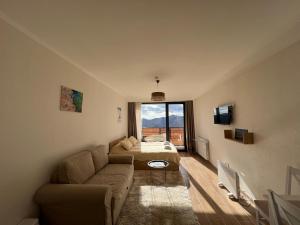 Twins #144 New Gudauri with Mountain View في غودواري: غرفة معيشة بها أريكة وسرير ونافذة