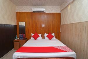 a bedroom with a large bed with red pillows at OYO 13234 Hotel Mahak in Bijnaur