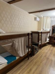 Pokój z 2 łóżkami piętrowymi i stołem w obiekcie ArArAt-OSOKORKI Hostel KYIV w Kijowie