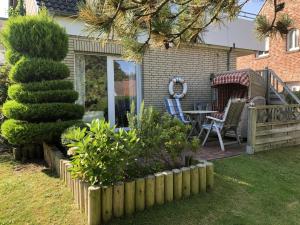a garden with a table and chairs on a patio at Fievfoten EG in Borkum