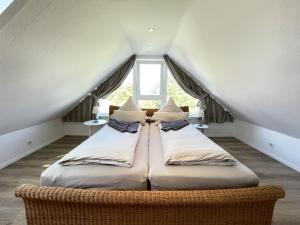 twee bedden in een kamer met een raam bij Fievfoten OG in Borkum