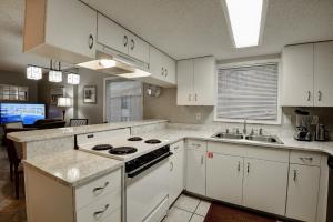 een keuken met witte kasten, een fornuis en een wastafel bij Clearwater 6D in Gulf Shores