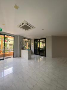 an empty lobby with a large white tile floor at ศิวพฤกษ์ เพลส in Nonthaburi +40 photos