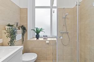 La salle de bains est pourvue d'une douche, de toilettes et d'un lavabo. dans l'établissement Balcony Apartment, 4 min to U3 Zipperer Straße, à Vienne