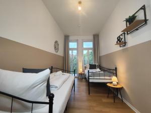 1 dormitorio con 1 cama, 1 silla y 1 ventana en BohnApartments Stauffenberg City - gratis Parkplatz - 2 Badezimmer - 3 Schlafzimmer - WLAN, en Erfurt