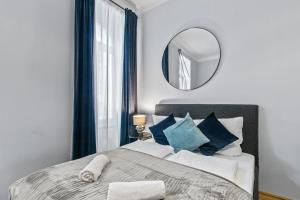 - une chambre avec un grand lit et un miroir dans l'établissement Balcony Apartment, 4 min to U3 Zipperer Straße, à Vienne
