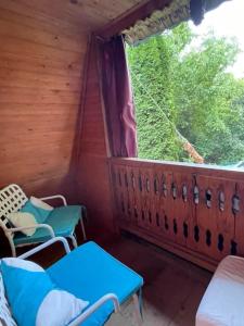 una habitación con sillas y una ventana en una cabaña en Nest in the Nature, en Brebu Megieşesc