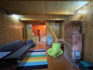 sala de estar con sofá y chimenea en Nest in the Nature, en Brebu Megieşesc