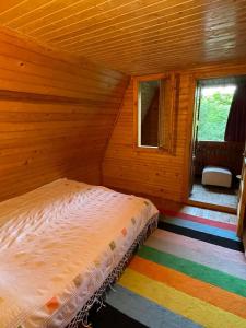 1 dormitorio con 1 cama en una habitación de madera en Nest in the Nature, en Brebu Megieşesc