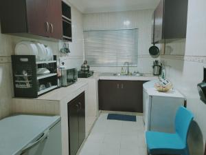 a small kitchen with a blue chair in it at 1 Bedroom Entire APT - Kitchen - Wi-Fi in Ikeja
