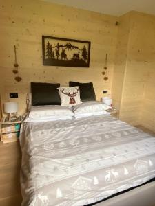 een slaapkamer met een groot wit bed in een kamer bij The Wooden House in Valle di Cadore