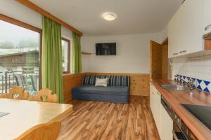 a kitchen with a couch in the corner of a room at Gästehaus Sieder by Schladming-Appartements in Schladming +26 photos